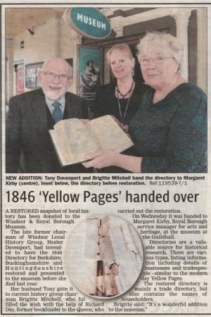 Friends and Staff standing in front of the Windsor & Royal Borough Museum, with one person holding an old directory while the others are smiling. The museum's sign is visible in the background.