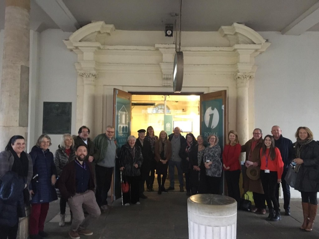 Group of people gathered in front of the entrance to the Windsor & Royal Borough Museum, showcasing a warm atmosphere with historical architecture in the background.