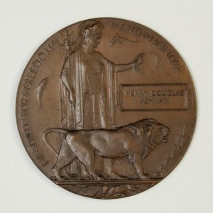 A bronze medallion commemorating the death of British soldiers in World War I, featuring a lion and a figure representing honor, inscribed with the name 'Henry Douglas Ashman'.