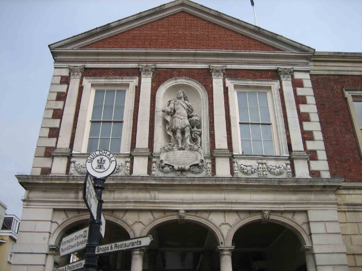 The exterior view of Windsor Guildhall, showcasing its iconic architecture with a central statue and large windows.
