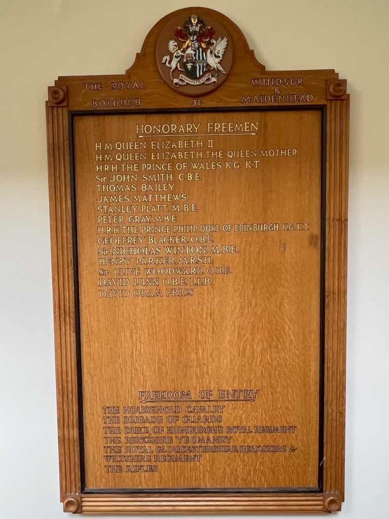 A wooden plaque displaying the names of honorary freemen of the Royal Borough of Windsor and Maidenhead, featuring a coat of arms at the top.