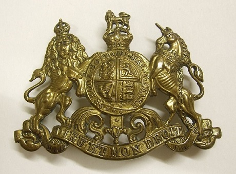 A bronze coat of arms featuring a lion and a unicorn, with the inscription 'Dieu et mon droit' at the bottom.